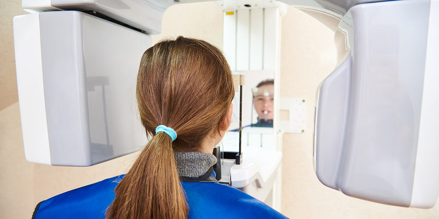A Patient In A Protective Suit Is Standing Next To The Device